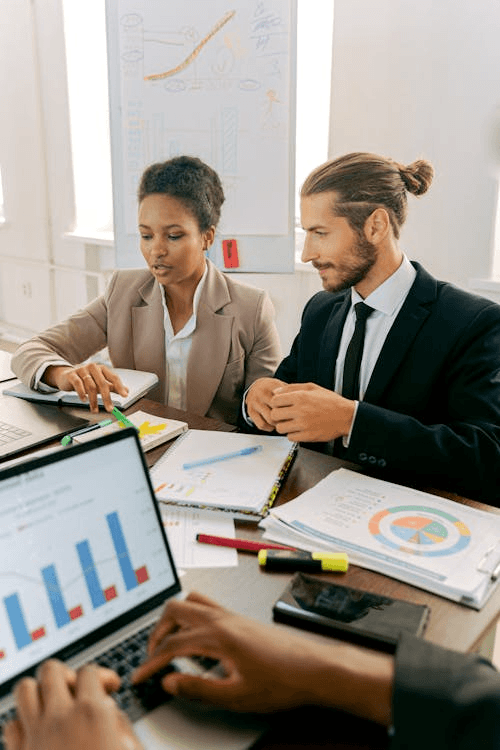 Small business team reviewing charts and notes together at a desk in a bright office